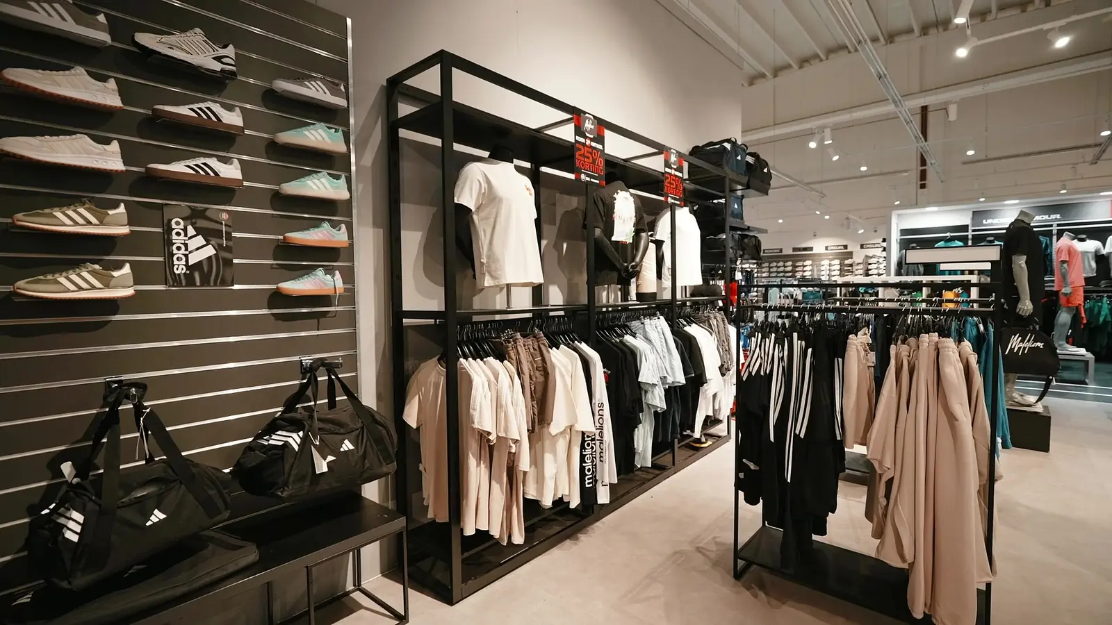 adidas-herenzuil met T-shirts en broeken aan een slatwall